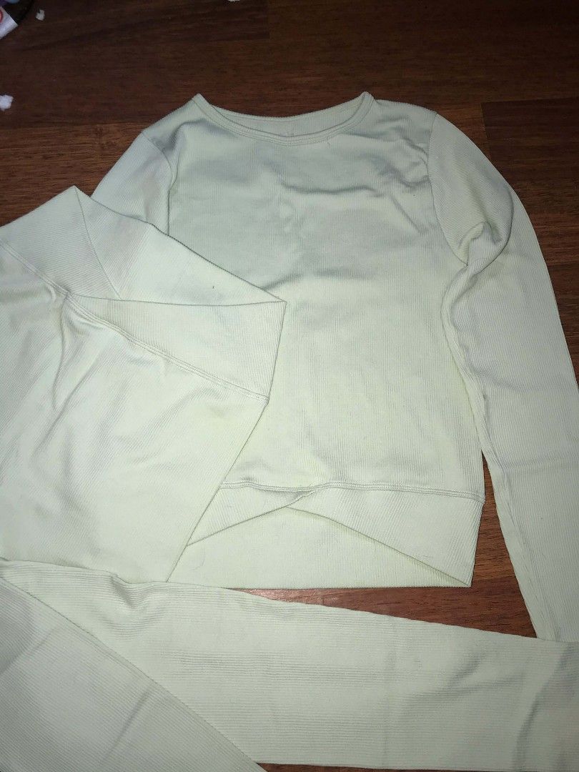 Aura Ribbed Activewear Set (Category: Activewear) located in Cebu City. Submitted by alwayssecondoption (Listing ID 1426963027, Image 1). Description: Activewear set includes a long-sleeved top and leggings. The top features a ribbed texture and a unique criss-cross design at the waist. The leggings have a high-waisted design. The set is made of a nylon and spandex blend. The label indicates the size is S/M. The color is a light green/mint green.