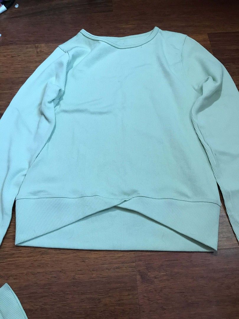 Aura Ribbed Activewear Set (Category: Activewear) located in Cebu City. Submitted by alwayssecondoption (Listing ID 1426963027, Image 3). Description: Activewear set includes a long-sleeved top and leggings. The top features a ribbed texture and a unique criss-cross design at the waist. The leggings have a high-waisted design. The set is made of a nylon and spandex blend. The label indicates the size is S/M. The color is a light green/mint green.