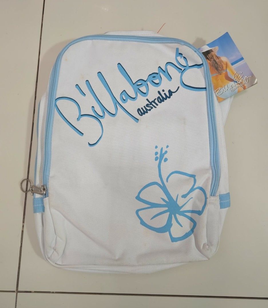 Billabong Australia Surfside Polyester Backpack (Category: Backpacks) located in Naga. Submitted by princessta62477 (Listing ID 1427082586, Image 1). Description: Billabong backpack features a white exterior with blue accents and a hibiscus flower design. It includes a zipper closure and a tag. The backpack is made of Surfside Polyester. The design includes the Billabong Australia logo. The backpack has a shoulder strap with the Billabong logo an