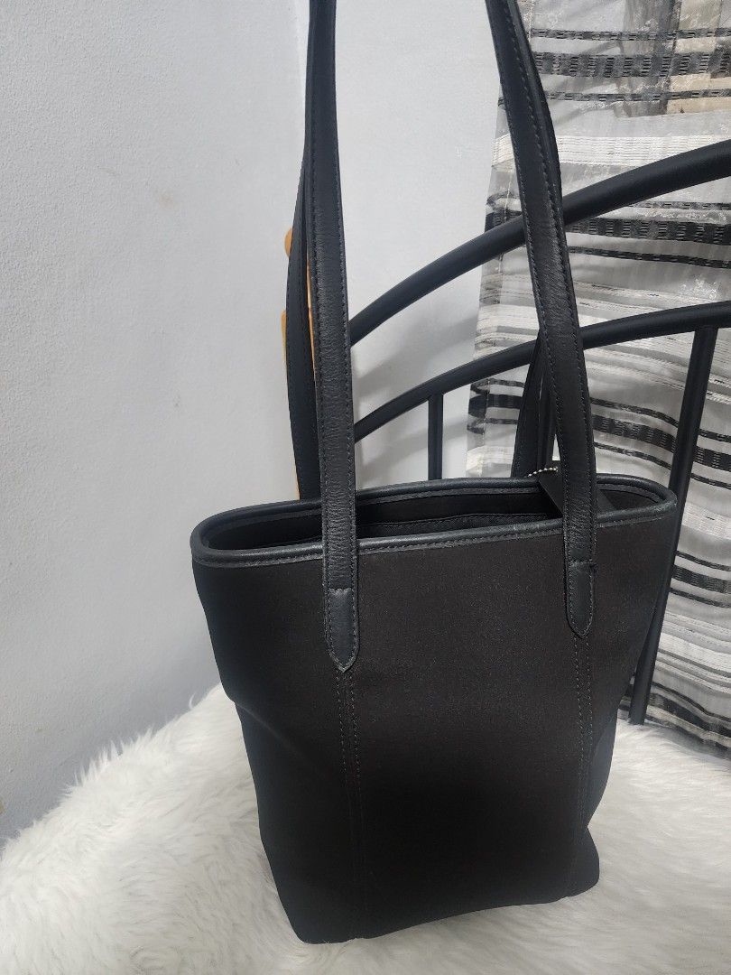 Coach Classic Solid Black Neoprene and Leather Tote Bag (Category: Luxury Bags & Wallets) located in Paranaque City. Submitted by rizasauthenticitems (Listing ID 1427113935, Image 3). Description: Black Coach tote bag with dual top handles and a detachable shoulder strap. Features 3 compartments with a zip in the middle closure and multiple interior pockets. Includes a Coach hang tag and a metal logo on the front..