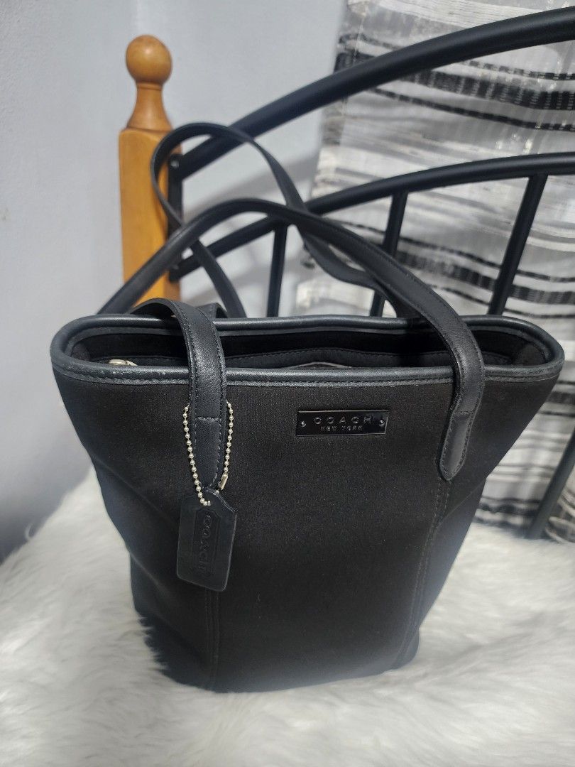 Coach Classic Solid Black Neoprene and Leather Tote Bag (Category: Luxury Bags & Wallets) located in Paranaque City. Submitted by rizasauthenticitems (Listing ID 1427113935, Image 2). Description: Black Coach tote bag with dual top handles and a detachable shoulder strap. Features 3 compartments with a zip in the middle closure and multiple interior pockets. Includes a Coach hang tag and a metal logo on the front..