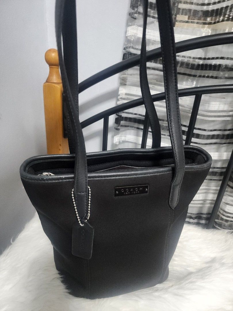 Coach Classic Solid Black Neoprene and Leather Tote Bag (Category: Luxury Bags & Wallets) located in Paranaque City. Submitted by rizasauthenticitems (Listing ID 1427113935, Image 1). Description: Black Coach tote bag with dual top handles and a detachable shoulder strap. Features 3 compartments with a zip in the middle closure and multiple interior pockets. Includes a Coach hang tag and a metal logo on the front..