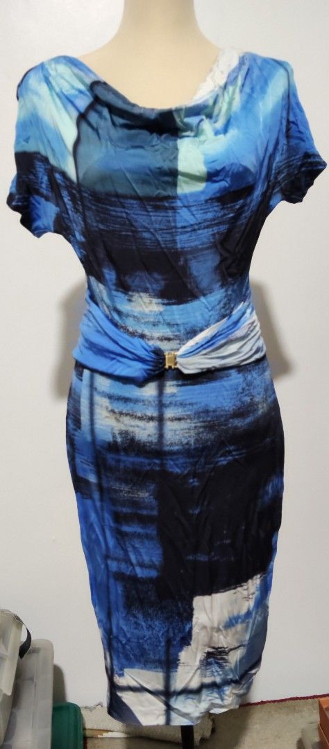 Escada Blue Print Dress (Category: Dresses) located in Manila. Submitted by audrey03 (Listing ID 1427133226, Image 2). Description: Elegant Escada dress featuring a unique blue print design. It has a cowl neckline and short sleeves. The dress is cinched at the waist with a gold-tone buckle. The dress has a knee-length hemline. The back of the dress has a similar print design..