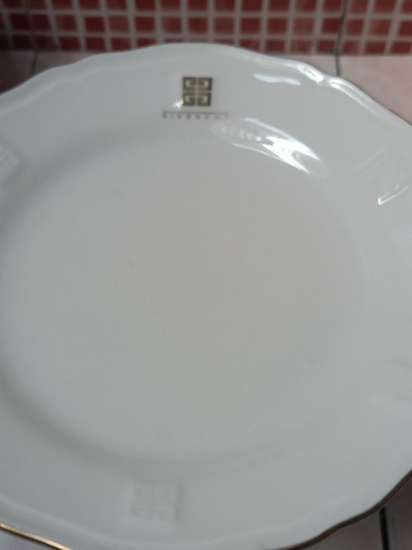 Givenchy Plate Set (Category: Dinnerware & Cutlery) located in Bulacan. Submitted by shop_369 (Listing ID 1427026746, Image 3). Description: Elegant Givenchy plate set featuring a white base with gold rim. The set includes large plates with the Givenchy logo FREE smaller plate with a floral design. FREE maroon pedestal dish..