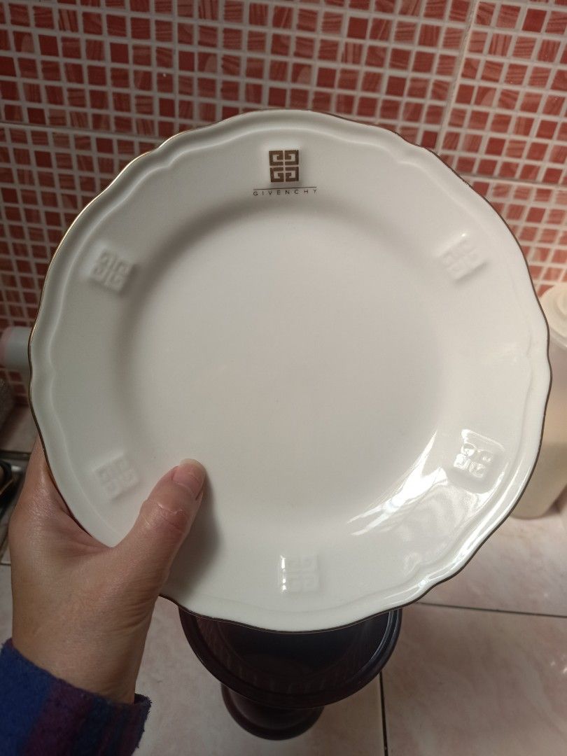 Givenchy Plate Set (Category: Dinnerware & Cutlery) located in Bulacan. Submitted by shop_369 (Listing ID 1427026746, Image 1). Description: Elegant Givenchy plate set featuring a white base with gold rim. The set includes large plates with the Givenchy logo FREE smaller plate with a floral design. FREE maroon pedestal dish..