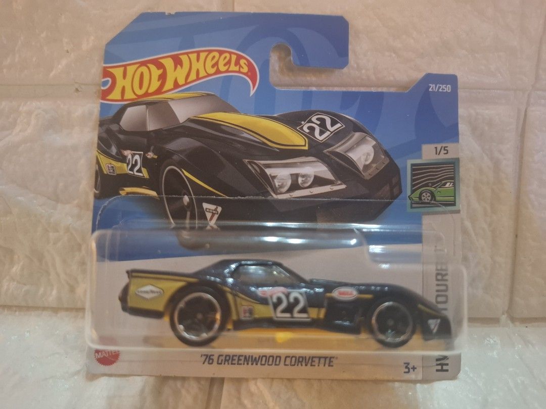 Hot Wheels '76 Greenwood Corvette (Category: Vehicle & Diecast Models) located in Narvacan. Submitted by jigger85_2ndaccount (Listing ID 1426977289, Image 1). Description: Hot Wheels diecast car features a '76 Greenwood Corvette. It has a black and yellow color scheme with the number 22 on the sides. The car is part of the 21/250 series and is 1/5 in the series. The packaging indicates it is suitable for ages 3+. The car is in its original packag