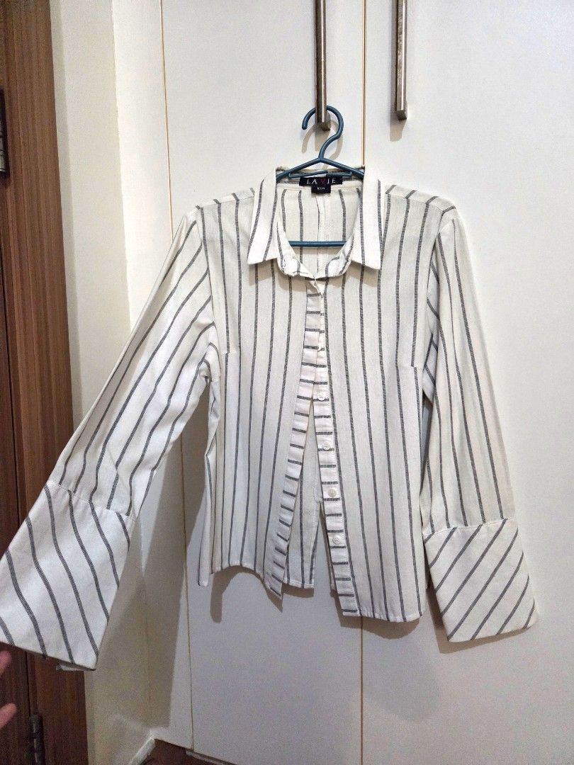 La Vie Striped Long Sleeve Blouse (Category: Blouses) located in Makati City. Submitted by shoppreloved_ (Listing ID 1427050912, Image 1). Description: White and gray striped blouse from La Vie. Features long sleeves with buttoned cuffs. The blouse has a collared neckline and a button-down front. Size XS/4. The blouse has a classic, versatile design suitable for the office and various occasions..