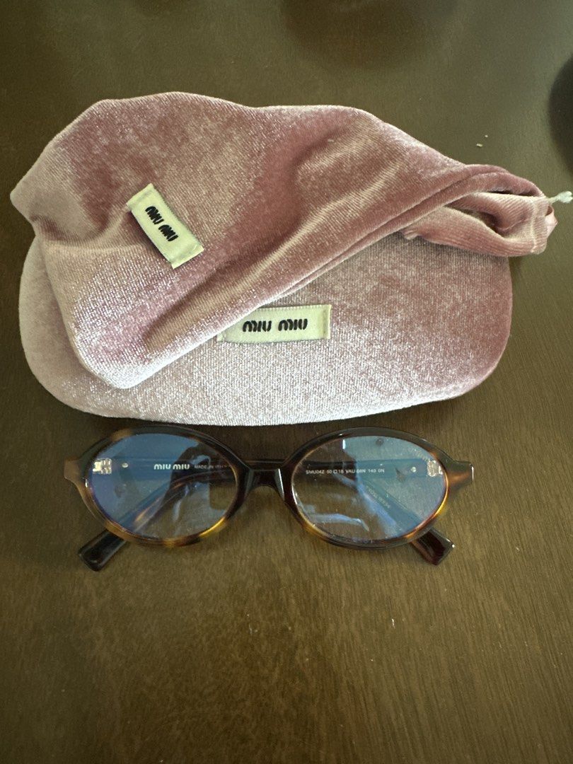 Miu Miu inspired Oval Eyeglasses (Category: Sunglasses & Eyewear) located in Pasig City. Submitted by kdcloset_2021 (Listing ID 1427001450, Image 1). Description: Miu Miu eyeglasses with a tortoise shell frame. Includes the original velvet case and cleaning cloth. The glasses have an oval shape. The frame has the Miu Miu logo on the temples. The case is a soft, dusty rose color..
