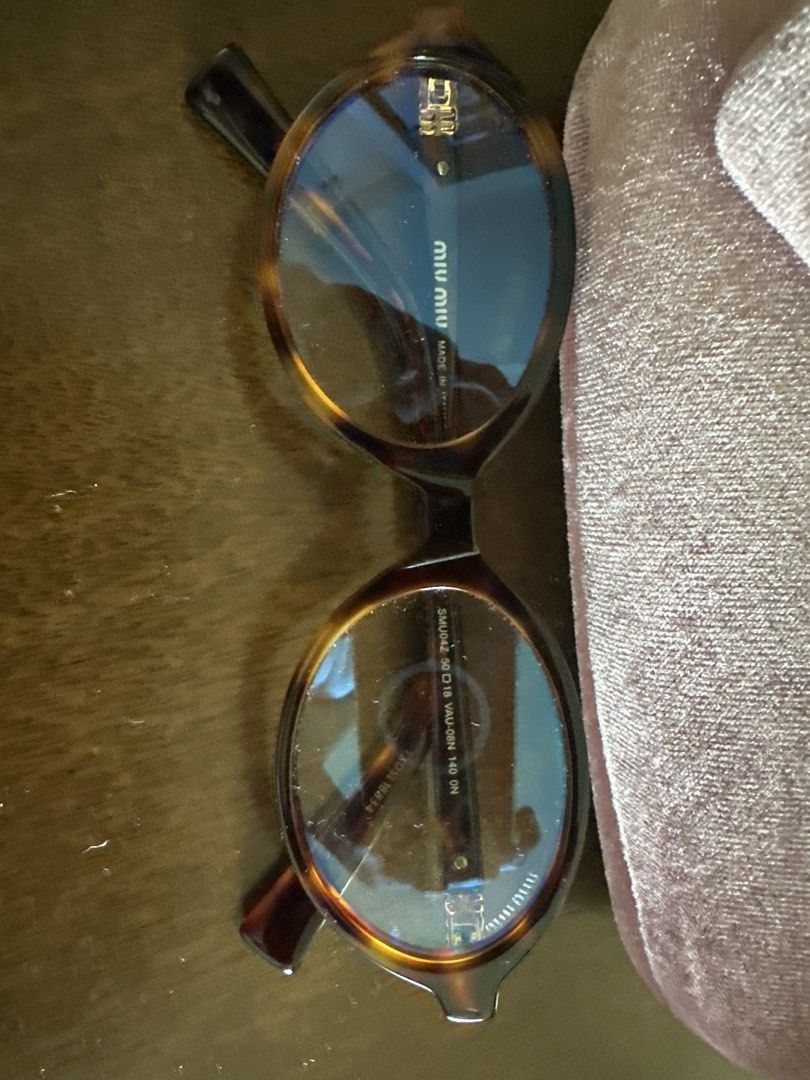 Miu Miu inspired Oval Eyeglasses (Category: Sunglasses & Eyewear) located in Pasig City. Submitted by kdcloset_2021 (Listing ID 1427001450, Image 2). Description: Miu Miu eyeglasses with a tortoise shell frame. Includes the original velvet case and cleaning cloth. The glasses have an oval shape. The frame has the Miu Miu logo on the temples. The case is a soft, dusty rose color..
