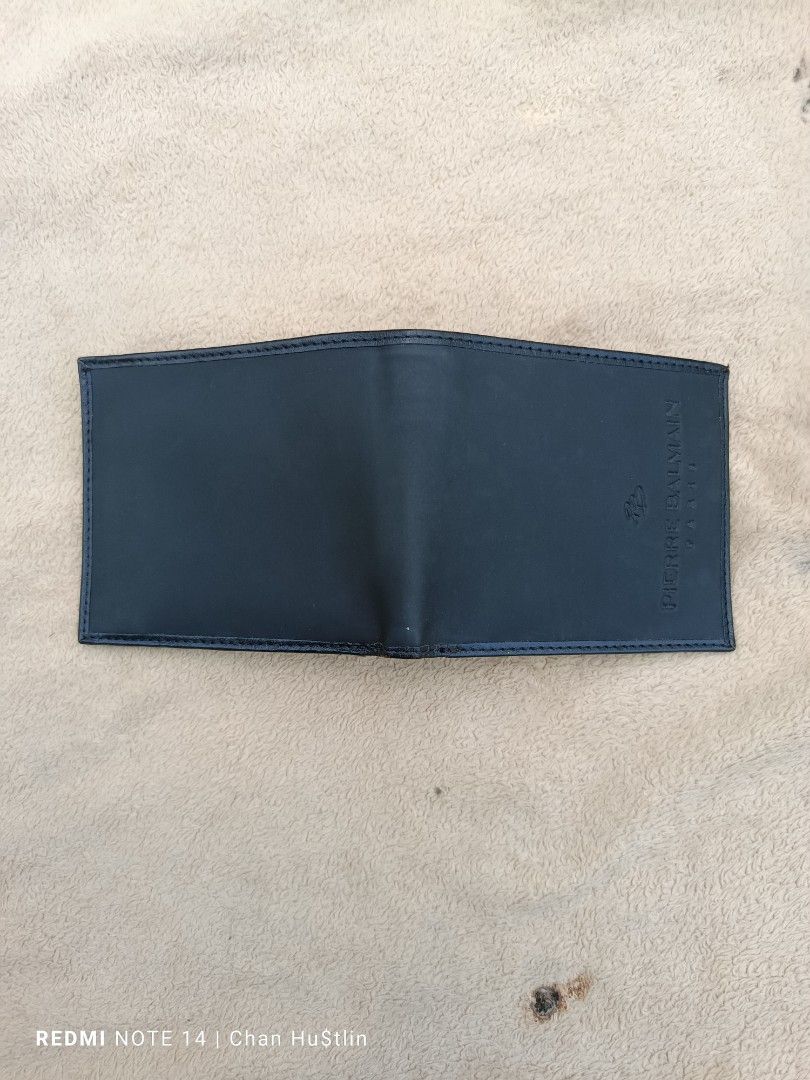 Pierre Balmain Black Leather Wallet (Category: Luxury Bags & Wallets) located in Calamba. Submitted by chanmagpantay (Listing ID 1426983823, Image 2). Description: Black leather wallet by Pierre Balmain. Features multiple card slots and a coin pocket. The brand name is embossed on the front and inside. It has a classic bi-fold design..