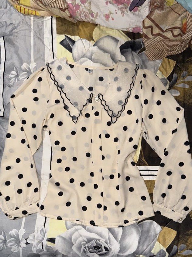Polka Dot Long Sleeve Blouse with Peter Pan Collar (Category: Blouses) located in Manila. Submitted by mayarii_ (Listing ID 1427148732, Image 1). Description: Blouse features a cream-colored fabric with black polka dots. It has a Peter Pan collar with black trim and long sleeves with buttoned cuffs. The blouse has a button-down front and a slightly fitted silhouette..