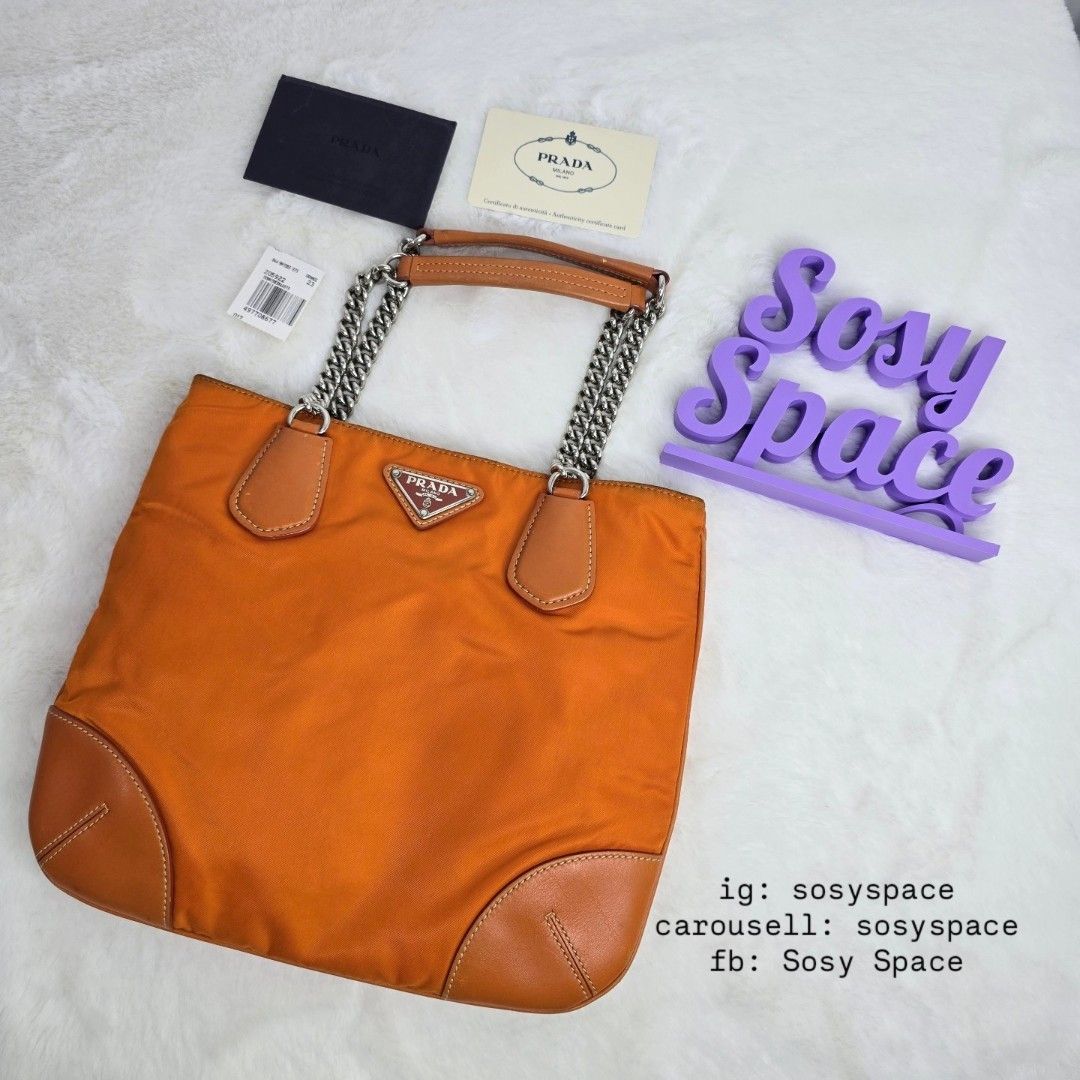 Prada Orange Tessuto Nylon Chain Tote Bag (Category: Luxury Bags & Wallets) located in Lucena. Submitted by sosyspace (Listing ID 1427068394, Image 1). Description: P. R. A. D. A. L06042325B1P69 Vintage Orange Tessuto Chain Handle Bag Leather Trim Silver Tone Hardware Magnetic Closure 1 Zip Pocket 10.75 x 1 x 9 inches Includes: authenticity card and Envelope Condition: PRELOVED Vintage Has signs of use and minor flaws Still in good condition for 