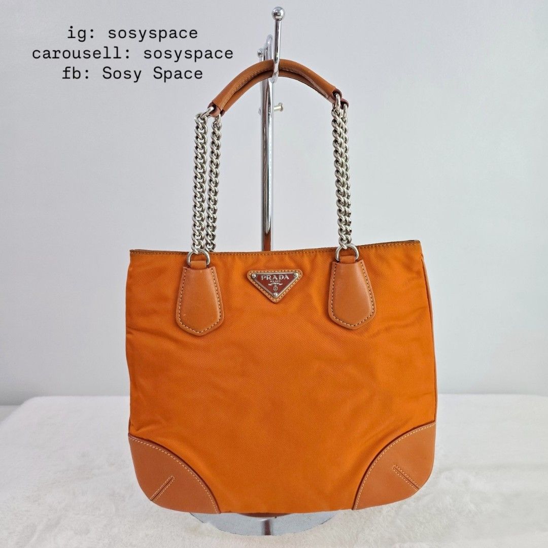 Prada Orange Tessuto Nylon Chain Tote Bag (Category: Luxury Bags & Wallets) located in Lucena. Submitted by sosyspace (Listing ID 1427068394, Image 2). Description: P. R. A. D. A. L06042325B1P69 Vintage Orange Tessuto Chain Handle Bag Leather Trim Silver Tone Hardware Magnetic Closure 1 Zip Pocket 10.75 x 1 x 9 inches Includes: authenticity card and Envelope Condition: PRELOVED Vintage Has signs of use and minor flaws Still in good condition for 