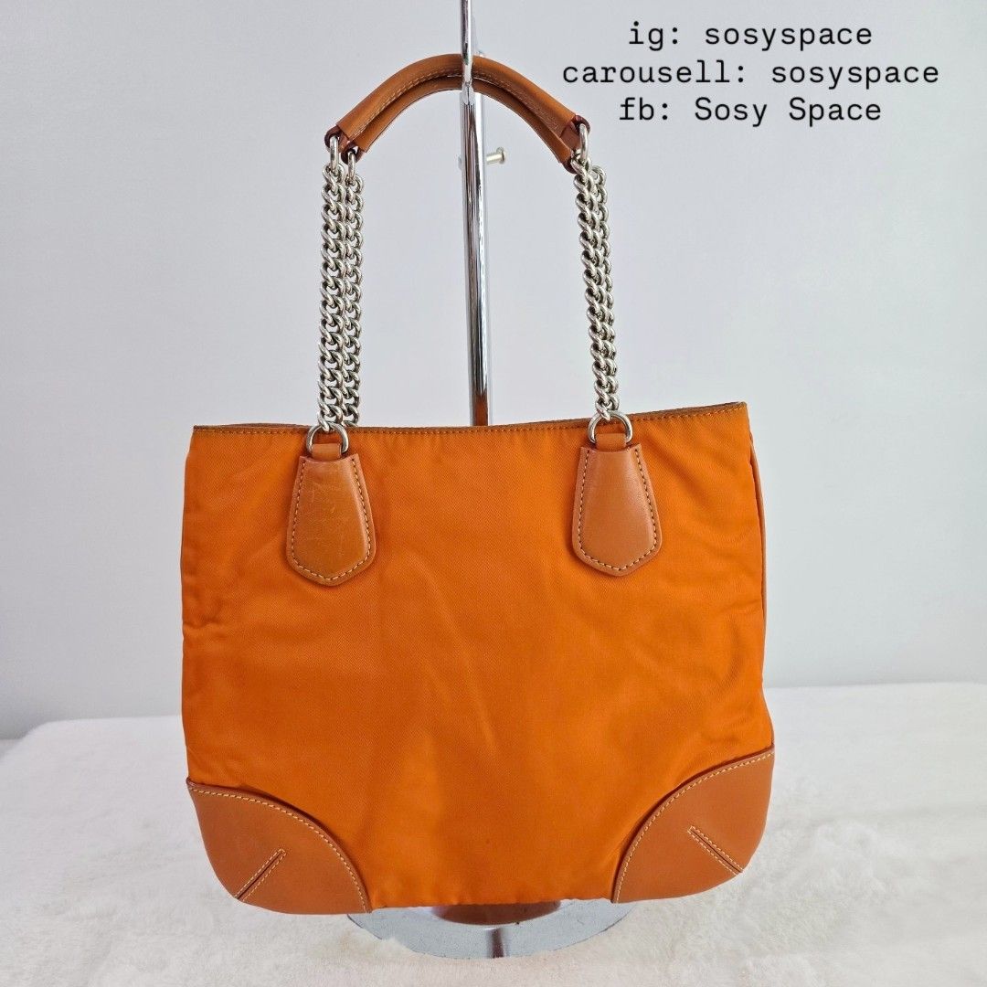 Prada Orange Tessuto Nylon Chain Tote Bag (Category: Luxury Bags & Wallets) located in Lucena. Submitted by sosyspace (Listing ID 1427068394, Image 3). Description: P. R. A. D. A. L06042325B1P69 Vintage Orange Tessuto Chain Handle Bag Leather Trim Silver Tone Hardware Magnetic Closure 1 Zip Pocket 10.75 x 1 x 9 inches Includes: authenticity card and Envelope Condition: PRELOVED Vintage Has signs of use and minor flaws Still in good condition for 