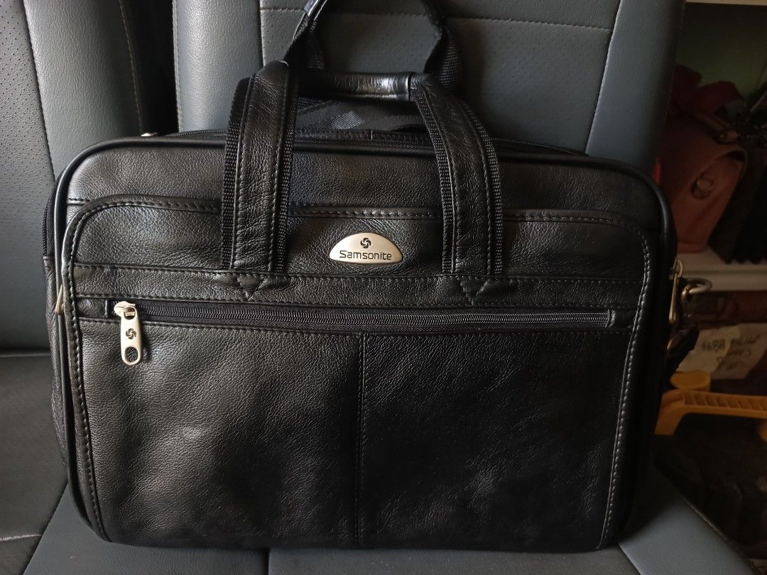 Samsonite Black Leather Briefcase (Category: Briefcases) located in Paracelis. Submitted by blessed_.0 (Listing ID 1426961553, Image 1). Description: vBlack leather briefcase from Samsonite. Features a front zipper pocket and a handle for carrying. The Samsonite logo is visible on the front. It has a rectangular shape and a zipper closure..
