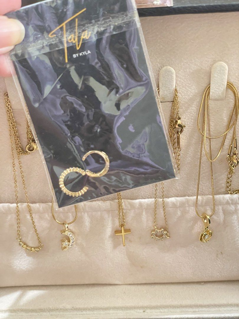Tala by Kyla Jewelry Set (Category: Necklaces) located in Bulacan. Submitted by kkaye_ (Listing ID 1427003614, Image 1). Description: TAKE ALL! Beautiful jewelry set from Tala by Kyla. The necklaces feature designs such as a crescent moon, hearts, a cross, sun shaped , and a poppy flower pendant. FREE 2 ear cuffs (never been used).