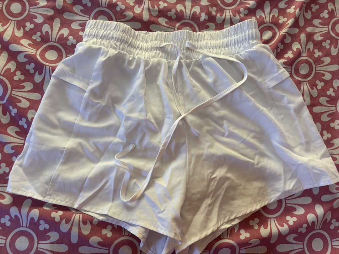 Woman Active White Shorts - Size M (Category: Shorts) located in Cebu City. Submitted by conductdisorder (Listing ID 1426984522, Image 1). Description: White shorts with an elastic waistband and drawstring. Features a built-in lining and pockets. The shorts are labeled as size M. Perfect for active wear or casual outings. Made by Woman Active..