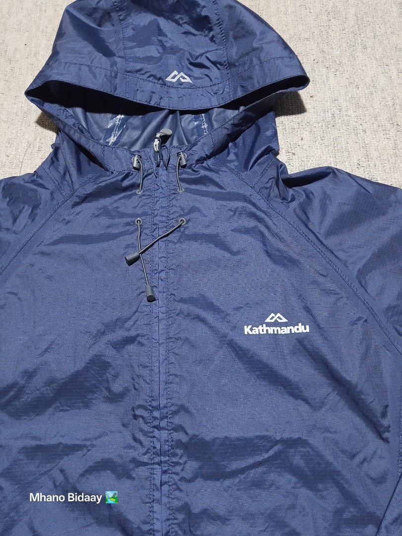 Kathmandu Men's Pocket-It Jacket - Medium (Category: Coats, Jackets and Outerwear) located in Valencia. Submitted by mhano_bidaay_outdoors_218 (Listing ID 1427214921, Image 3). Description: Kathmandu Men's Pocket-It Jacket in size Medium. Features a quick-drying fabric and a hood. Chest width is 23 inches, and the length is 28 inches. The jacket is navy blue. There is minimal chipping on the coating near the wrist. The seams are still intact but 