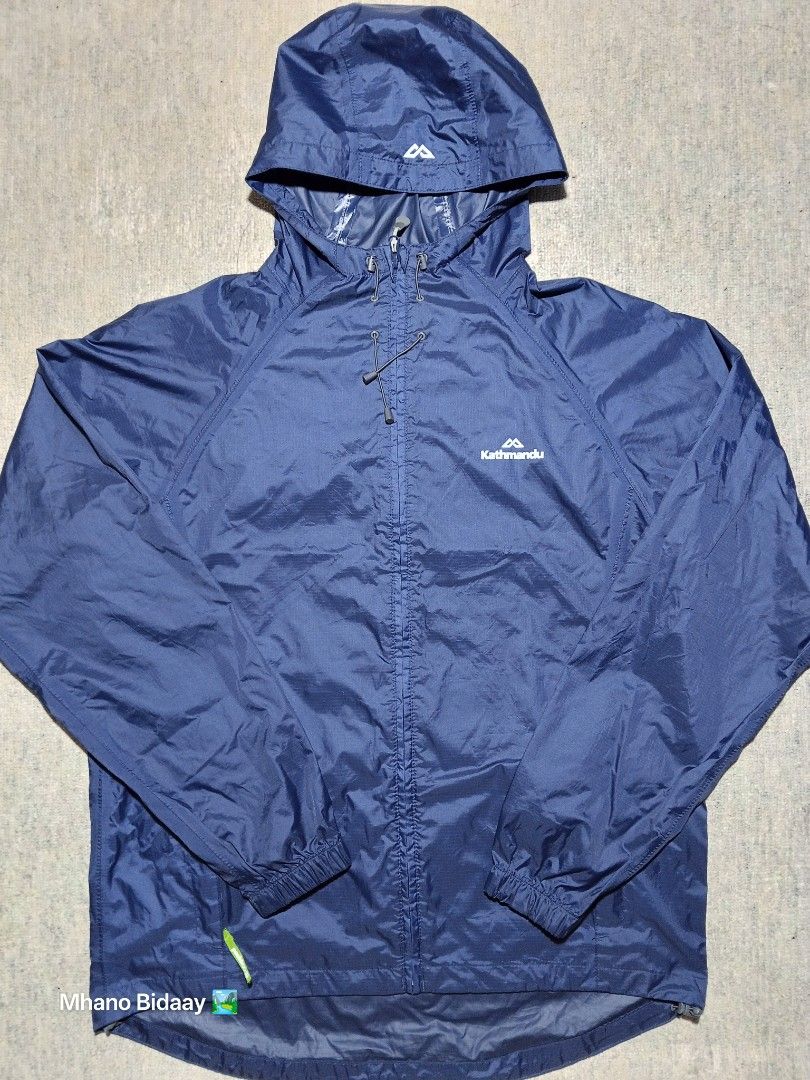 Kathmandu Men's Pocket-It Jacket - Medium (Category: Coats, Jackets and Outerwear) located in Valencia. Submitted by mhano_bidaay_outdoors_218 (Listing ID 1427214921, Image 2). Description: Kathmandu Men's Pocket-It Jacket in size Medium. Features a quick-drying fabric and a hood. Chest width is 23 inches, and the length is 28 inches. The jacket is navy blue. There is minimal chipping on the coating near the wrist. The seams are still intact but 