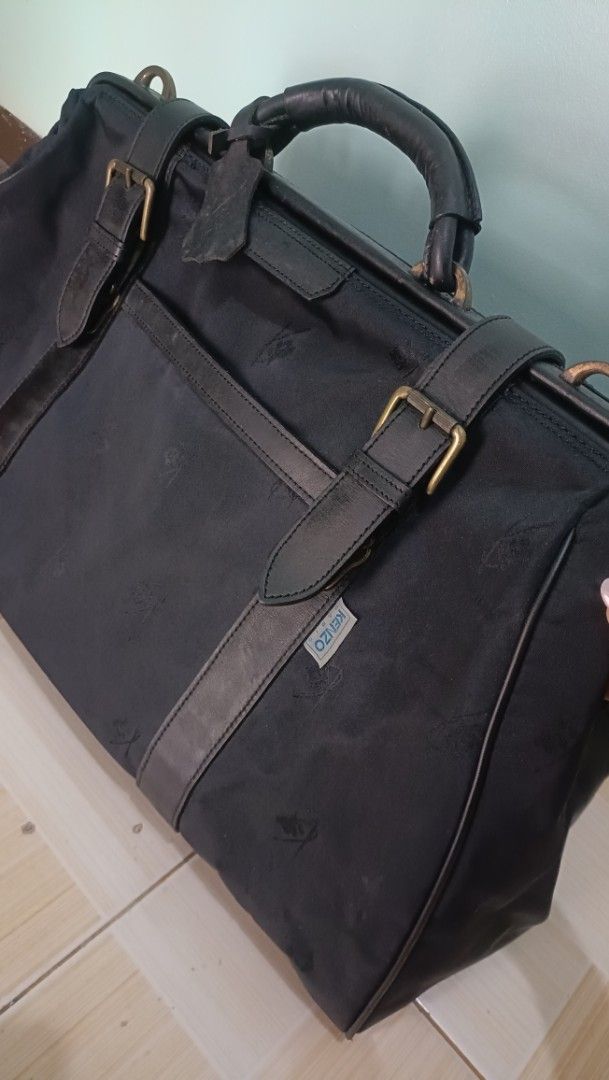 Kenzo Paris Duffle Bag (Category: Luxury Bags & Wallets) located in Las Pinas. Submitted by sarahlayan25584 (Listing ID 1427202402, Image 3). Description: Black duffle bag from Kenzo Paris. Features leather accents, a top handle, and a shoulder strap. Includes a main compartment and an interior pocket. The bag has a zipper closure with a branded zipper pull. The Kenzo Paris label is visible inside the bag. The bag has some signs of wear. -Replace