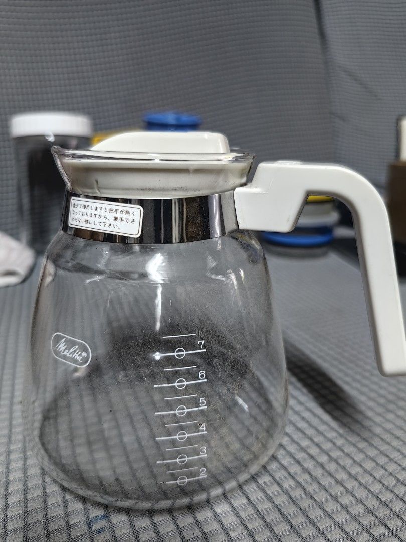 Melitta Glass Coffee Server (Category: Coffee & Tea Tableware) located in Rizal. Submitted by gkstcenit (Listing ID 1427165020, Image 3). Description: Melitta coffee server features a clear glass body with a white handle and lid. It has a stainless steel band around the top and a measurement scale on the side. The lid has a white plastic piece for pouring..