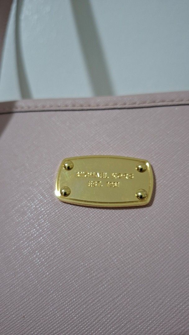Michael Kors Pink Tote Bag (Category: Luxury Bags & Wallets) located in Imus. Submitted by pick_and_dig (Listing ID 1427311196, Image 3). Description: Michael Kors tote bag is in a soft pink color. It features a spacious interior with multiple pockets, including a zippered compartment. The bag has double handles and gold-tone hardware. The interior lining is patterned with the Michael Kors logo. MOP: GCash, Maya Free delivery within the Philippin