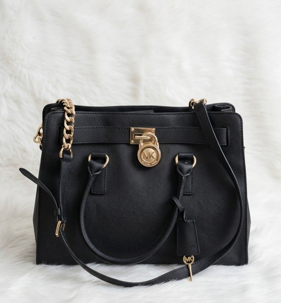 Michael Kors Selma Satchel Black (Category: Luxury Bags & Wallets) located in Balanga. Submitted by nea_mich (Listing ID 1427202424, Image 1). Description: - Black Michael Kors Selma satchel handbag. - Features a gold-tone chain strap and lock closure. Includes a detachable shoulder strap. - The interior has multiple compartments. - The hardware is gold-toned. - Includes a Michael Kors hang tag. Note: Negotiable SF not included Pm me for more inf