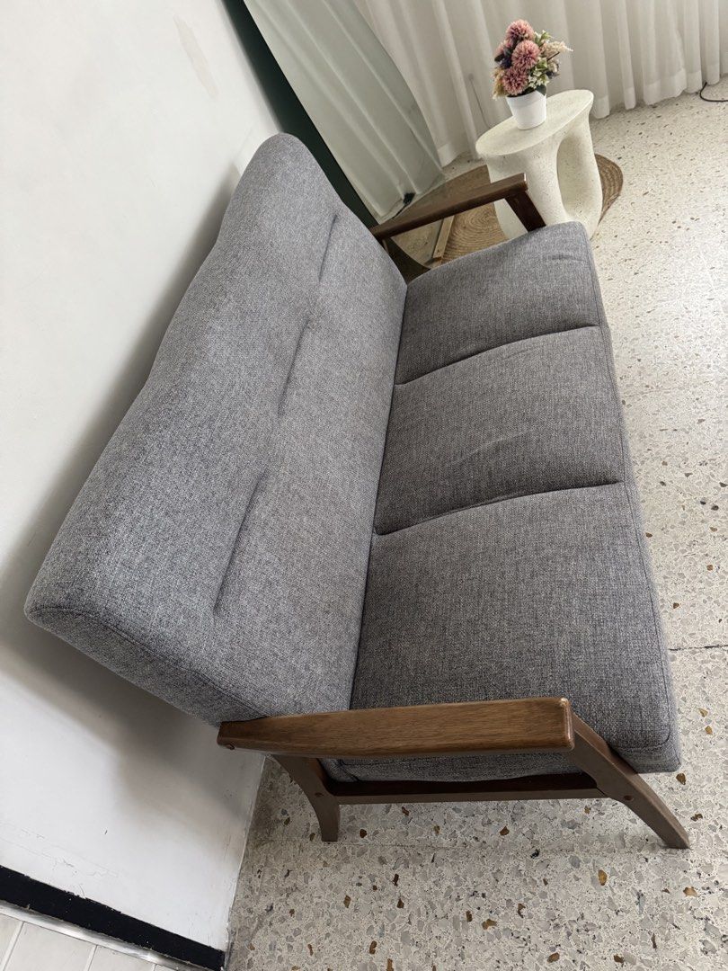Mid-Century Modern 3-Seater Sofa (Category: Sofas) located in Caloocan City. Submitted by andii.rhei (Listing ID 1419858102, Image 3). Description: - 3-seater sofa - Mid-century modern design - Gray fabric upholstery - Wooden frame and armrests - Clean, minimalist aesthetic - Ideal for living rooms and lounges -Cotton fabric seat - Three-section cushions - Sturdy wooden legs.