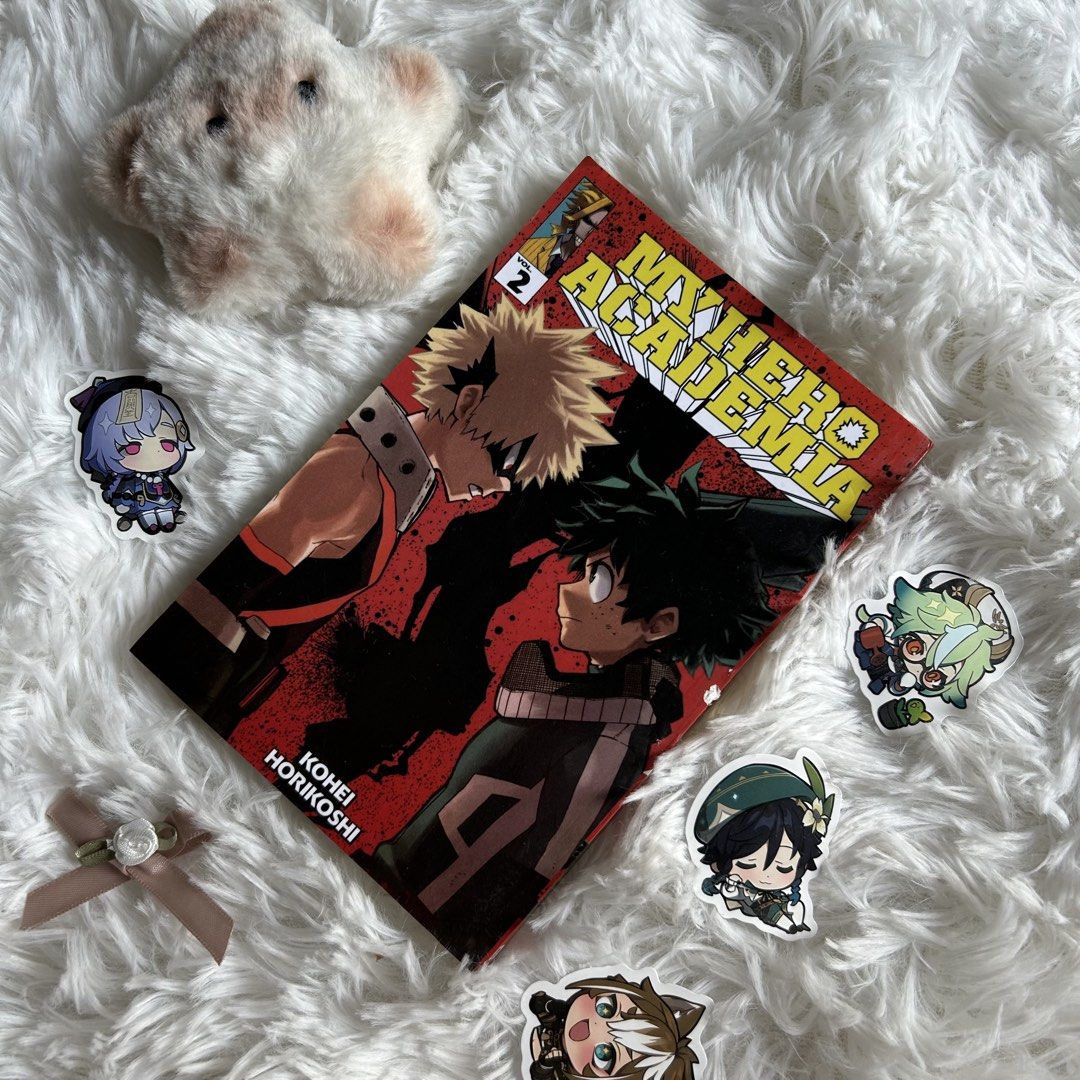 My Hero Academia Volume 2 (Category: Comics & Manga) located in Dinalupihan. Submitted by neousiea (Listing ID 1427288892, Image 1). Description: (boku no hero vol 2 - ₱189) — english ver — has some dents — slight scratch on the side of the bookbind — still in good and readable condition My Hero Academia Volume 2 manga. Features Deku and Bakugo on the cover. Includes stickers of various anime characters. Perfect for fans of the series..