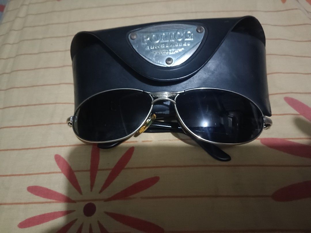 Police Sunglasses 2357 (Category: Sunglasses & Eyewear) located in Caloocan City. Submitted by jee2727 (Listing ID 1427273148, Image 2). Description: Stylish Police sunglasses with a silver frame and dark lenses. Includes the original case. The model number is 2357. The sunglasses are marked "Made in Italy". The case has the Police logo on it. The sunglasses have a sleek, modern design..