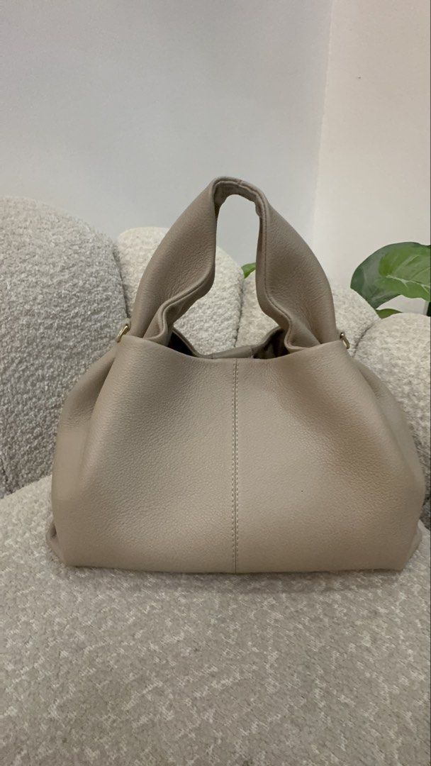 Polène Numéro Sept Mini Handbag (Category: Luxury Bags & Wallets) located in Caloocan City. Submitted by dyowanajav18292 (Listing ID 1427219051, Image 3). Description: Polène Numéro Sept Mini handbag in a taupe color. It features a top handle and a flap closure. The bag has a detachable shoulder strap. The bag is sitting on a gray textured surface..