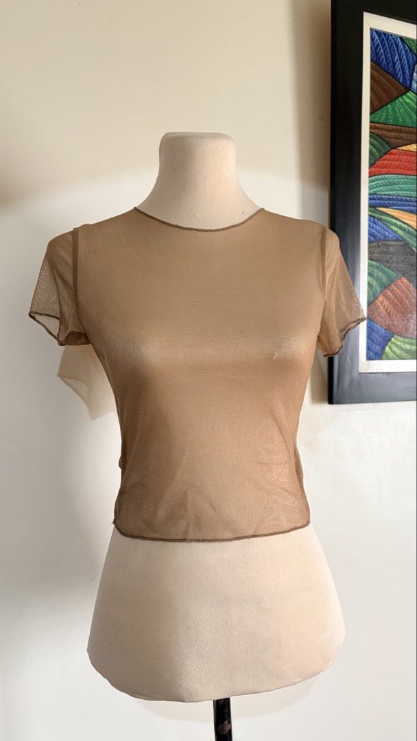 Shein Mesh Top - Size S (Category: Blouses) located in Mexico. Submitted by ivorybyfifth (Listing ID 1427190846, Image 1). Description: Shein mesh top in a neutral tan color. Features short sleeves and a round neckline. The tag indicates a size S. Made in China. A versatile piece that can be layered or worn on its own. Perfect for adding a touch of texture to any outfit..
