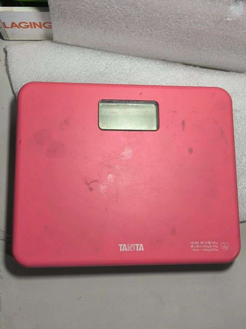 Tanita Digital Bathroom Scale (Category: Health Monitors & Weighing Scales) located in Angeles City. Submitted by yellowbrickstore (Listing ID 1427177493, Image 1). Description: Pink Tanita digital bathroom scale. Requires 2 AAA batteries (not included). The scale's dimensions are approximately 20cm x 24cm. The scale has some visible wear and tear. The display screen is visible in the center. The brand name "Tanita" is printed on the front. item 