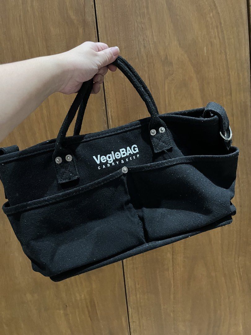 Vegle Bag Carry & Keep Tote Bag/Caddy (Category: Tote Bags) located in Manila. Submitted by artsygunda (Listing ID 1427242308, Image 2). Description: Black tote bag from Vegle Bag. Features multiple exterior pockets and a main compartment. Includes a detachable strap for shoulder or crossbody wear. The bag has two handles for carrying by hand. The interior has a small pocket. The bag is made of a sturdy, possibly canvas-like material. -used it as