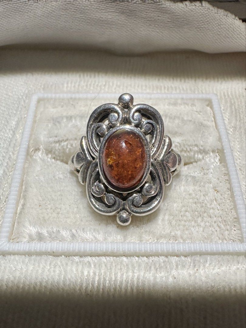 Vintage 925 Silver Baltic Amber Cabochon Stone Ring (Category: Rings) located in Mandaluyong City. Submitted by chyckenwings (Listing ID 1427287187, Image 1). Description: Vintage ring features an art nouveau style amber cabochon stone set in an ornate silver 925 metal. The ring has a detailed, scroll-like design around the stone. Slight chip on the gemstone possibly from old age which is common in amber since it's a relatively soft stone. Good i