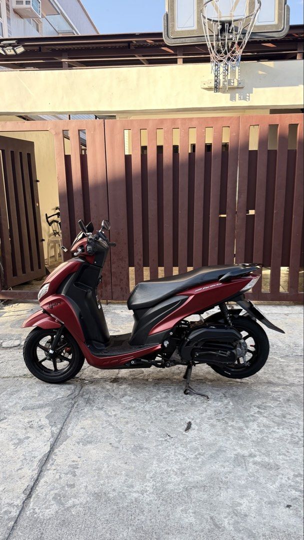Yamaha Mio Gravis (Category: Motorbikes for Sale) located in Las Pinas. Submitted by jalani01 (Listing ID 1427232130, Image 3). Description: Maroon Yamaha Mio Gravis scooter 2020 Features a black seat, black wheels, and a black windshield. The scooter has a license plate number 293NPL. The scooter is parked on a concrete surface. mio gravis 125 2020 model color: matte red plate: 293NPL complete legal papers under my name complete 2keys all workin
