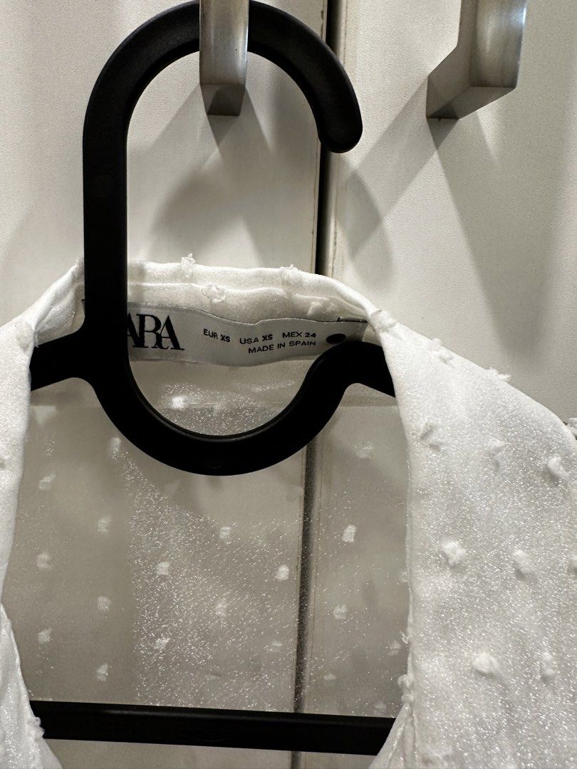 Zara White Poplin Top size XS (Category: Blouses) located in Quezon City. Submitted by declutter___mnl (Listing ID 1427201599, Image 3). Description: White blouse from Zara with polka dot detailing. Features a collared neckline and button-down closure. The sleeves are sheer and puffy. Size XS. Made in Spain..