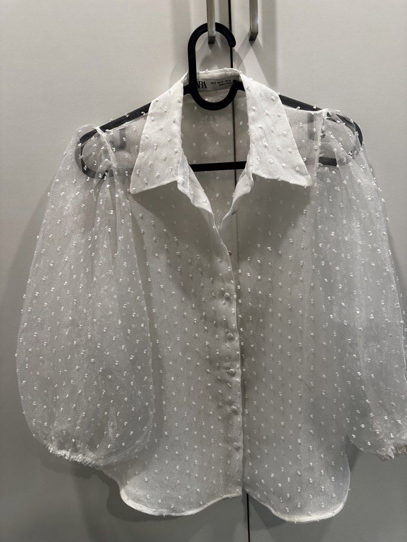 Zara White Poplin Top size XS (Category: Blouses) located in Quezon City. Submitted by declutter___mnl (Listing ID 1427201599, Image 1). Description: White blouse from Zara with polka dot detailing. Features a collared neckline and button-down closure. The sleeves are sheer and puffy. Size XS. Made in Spain..