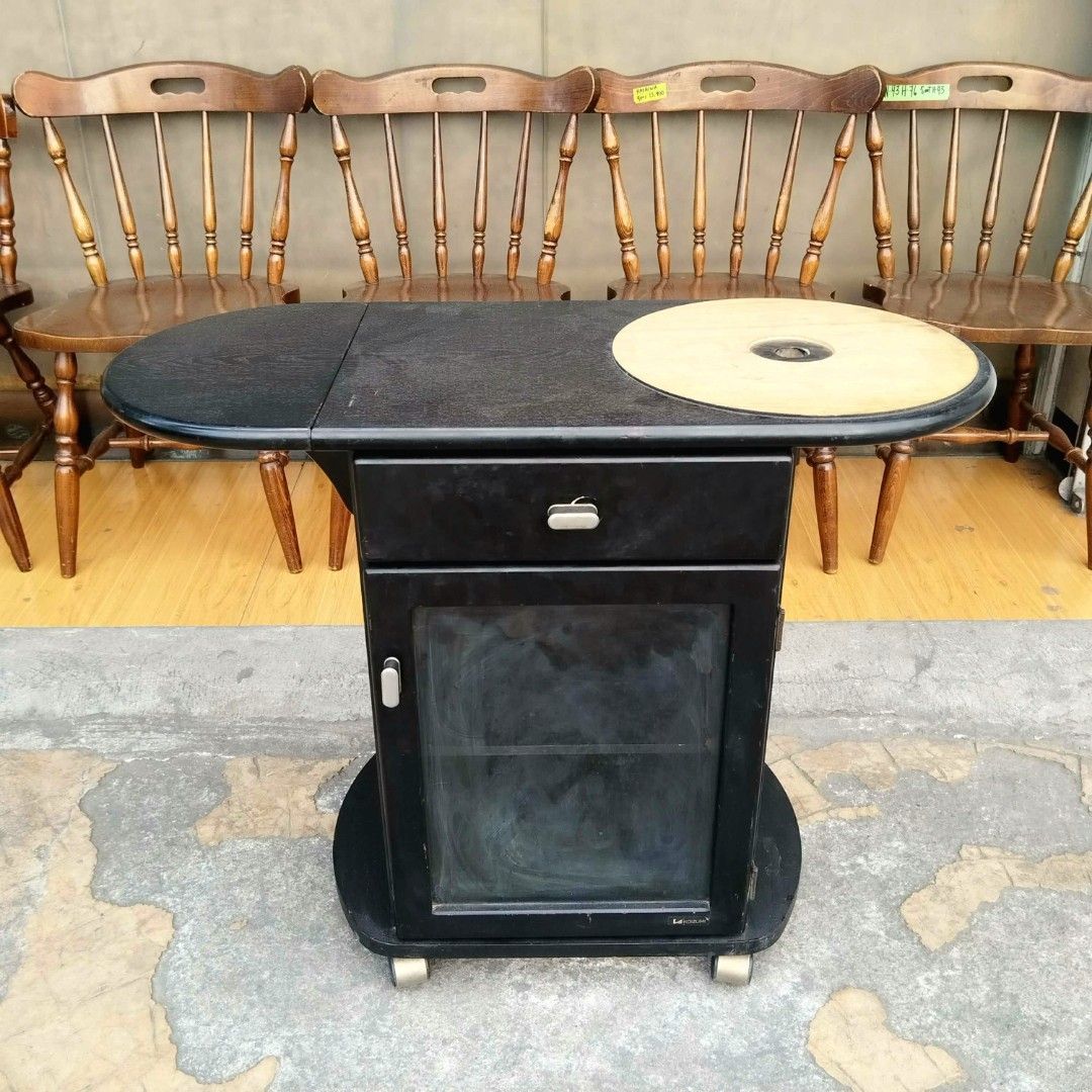 2nd hand KOIZUMI Rolling Extendable Table with Drawer (Category: Tables & Sets) located in Paranaque City. Submitted by feybelhaft (Listing ID 1427401040, Image 1). Description: Koizumi side table features a unique design with a drawer and a cabinet with a glass door. It has a circular inset on the top surface. The table is black and has a pull-out extension. It is mounted on wheels for easy movement. Dimensions are L60-83, W38, and H66cm..