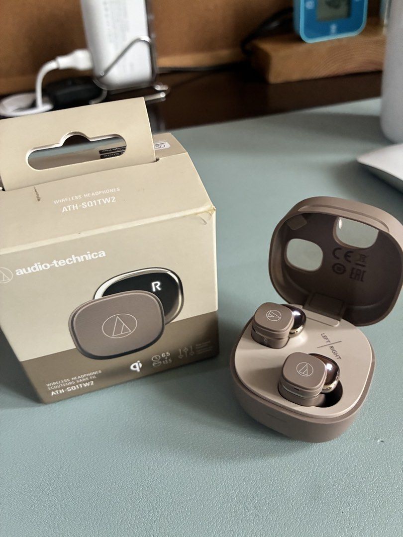 Audio-Technica ATH-S011TW2 Wireless Earbuds (Category: Earphones) located in Makati City. Submitted by dailyticker (Listing ID 1427365134, Image 2). Description: Audio-Technica ATH-S011TW2 wireless earbuds. Comes with the original box. The charging case and earbuds are in a tan color. The case has a 'Left' and 'Right' indicator. The box shows the earbuds and case. The box also indicates compatibility with the App Store and Google Play. Used only 