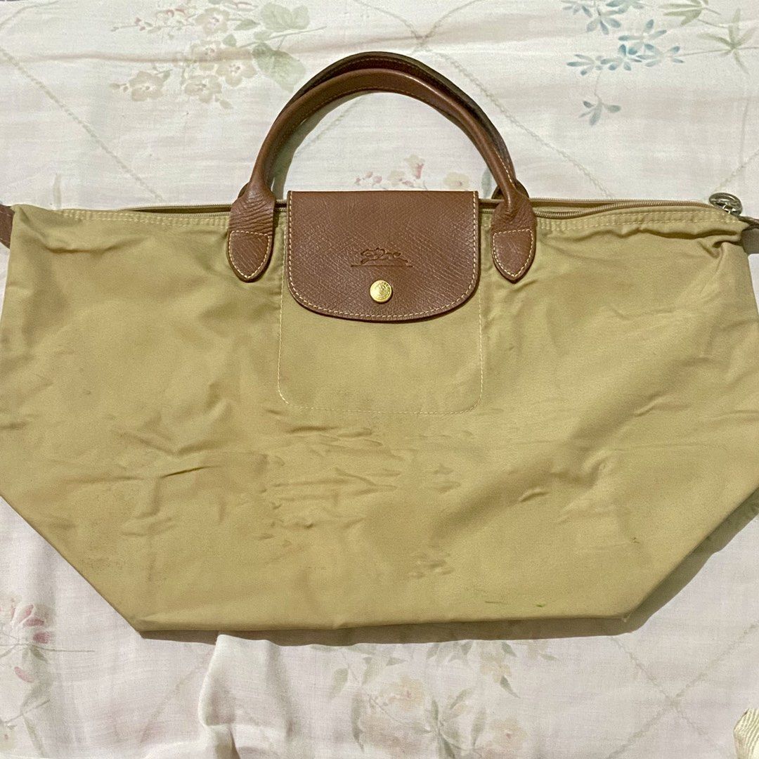authentic longchamp le pliage medium tote bag (khali in nylon with gold-tone) (Category: Luxury Bags & Wallets) located in Manila. Submitted by decluttered67 (Listing ID 1427325708, Image 1). Description: • authenticity: 100% authentic. features original interior clear tag, “prym” snap button, and branded ykk zipper. • size/style: medium (m) with short handles. khaki color with gold-tone buttons. • rfs: bought a new longchamp. selling this for a 