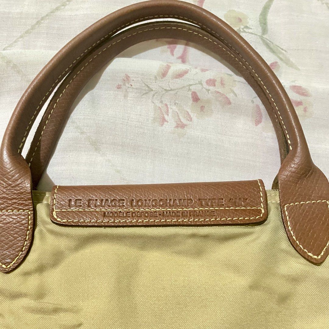 authentic longchamp le pliage medium tote bag (khali in nylon with gold-tone) (Category: Luxury Bags & Wallets) located in Manila. Submitted by decluttered67 (Listing ID 1427325708, Image 3). Description: • authenticity: 100% authentic. features original interior clear tag, “prym” snap button, and branded ykk zipper. • size/style: medium (m) with short handles. khaki color with gold-tone buttons. • rfs: bought a new longchamp. selling this for a 