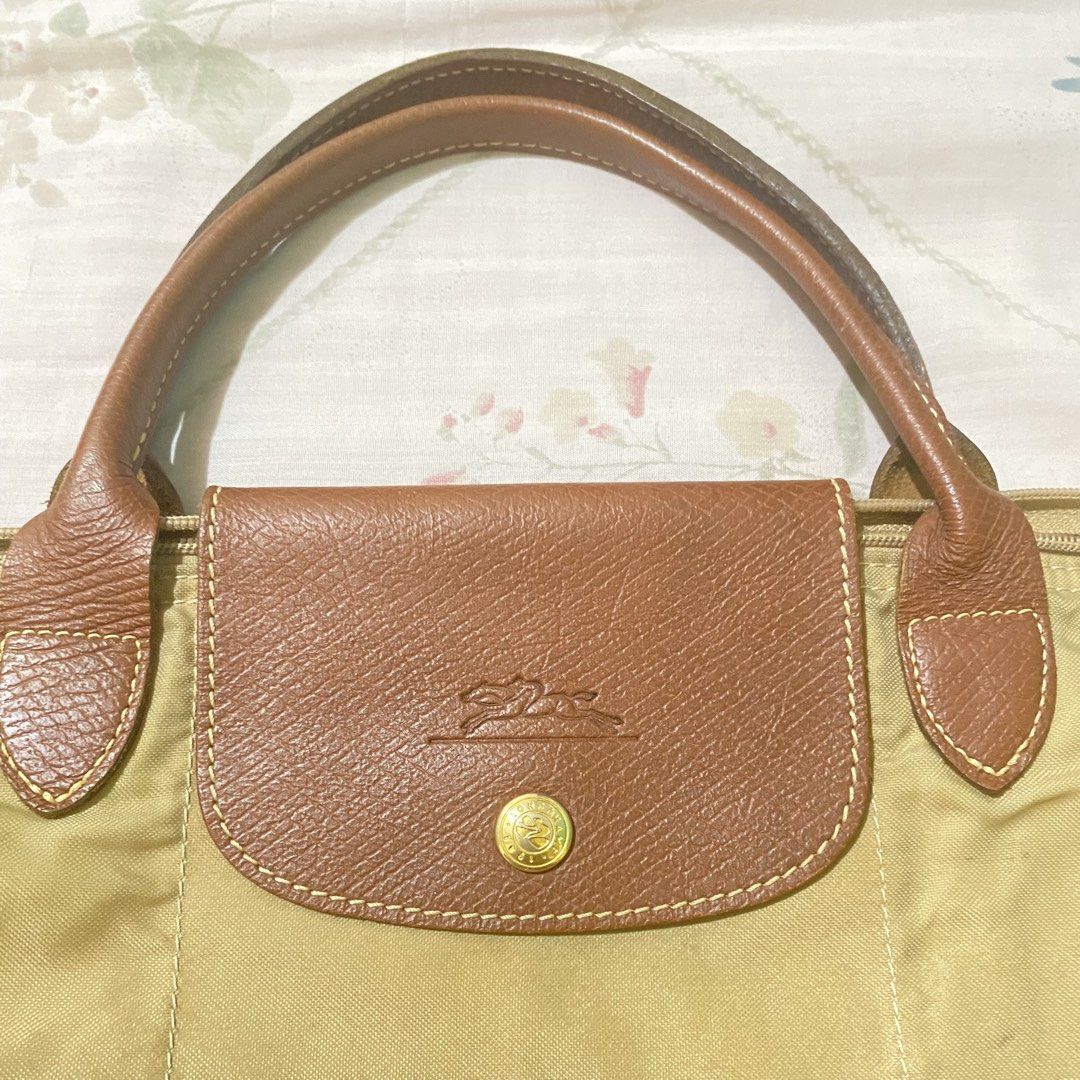 authentic longchamp le pliage medium tote bag (khali in nylon with gold-tone) (Category: Luxury Bags & Wallets) located in Manila. Submitted by decluttered67 (Listing ID 1427325708, Image 2). Description: • authenticity: 100% authentic. features original interior clear tag, “prym” snap button, and branded ykk zipper. • size/style: medium (m) with short handles. khaki color with gold-tone buttons. • rfs: bought a new longchamp. selling this for a 