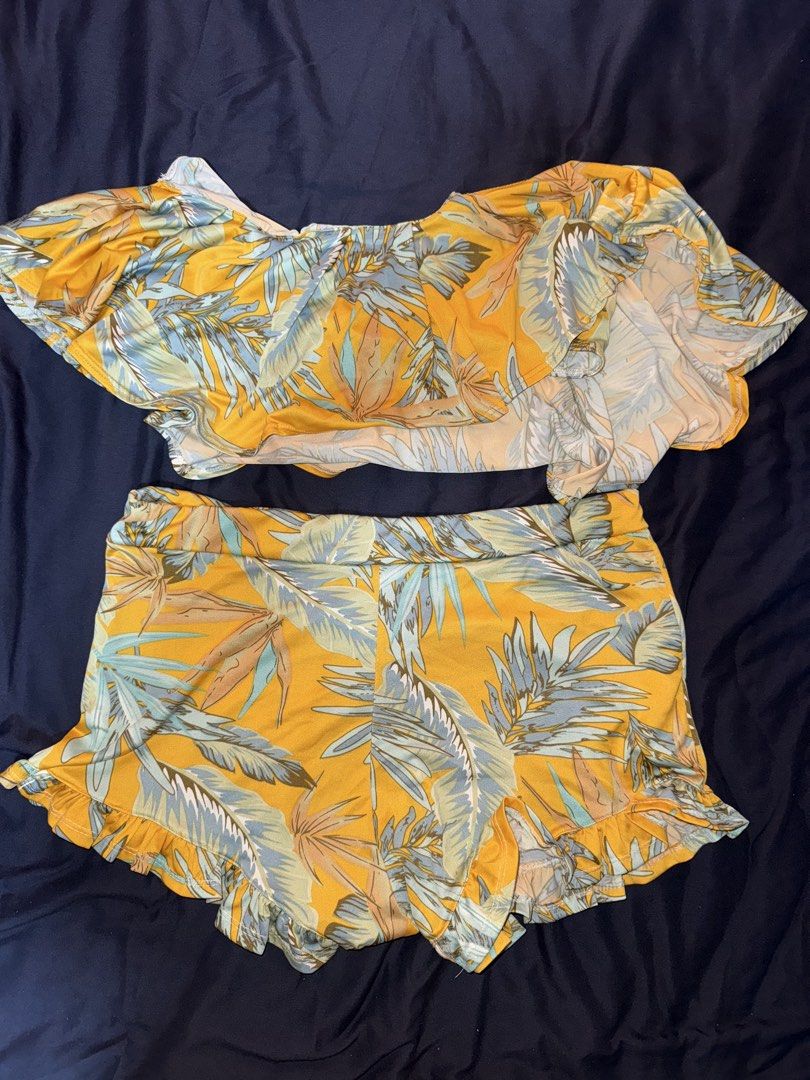 Floral Two-Piece Set (Category: Bikinis & Swimsuits) located in Valenzuela. Submitted by mighty.tepitepi (Listing ID 1427354890, Image 1). Description: Two-piece set features a vibrant floral print. The top is an off-shoulder style with a ruffled edge. The shorts have a high waist and a matching ruffled hem. The set is made of a lightweight fabric, perfect for warm weather. It's a stylish and comfortable outfit for casual wear or a day out. Not p