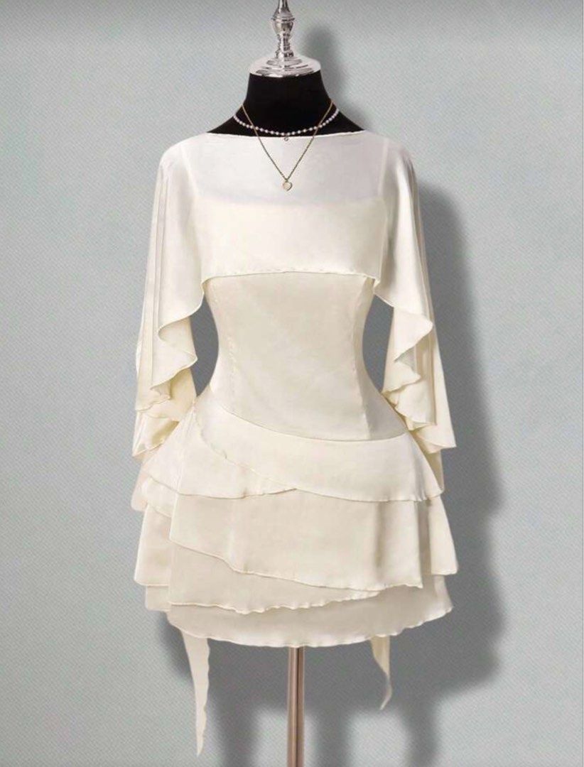 [FOR RENT] Elegant Classy Old Money Chic Sophisticated White Ruffled Mini Dress with Cape Scarf Silk Sleeves (Category: Dresses) located in Pasig City. Submitted by ilovenico (Listing ID 1427335545, Image 1). Description: Elegant white mini dress featuring a layered, ruffled skirt and a unique cape sleeve design. The dress has a fitted bodice and a low back with tie-up details. It includes a delicate necklace. Perfect for special occasions or a s