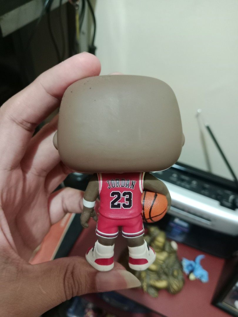 Funko Pop! Michael Jordan Chicago Bulls (Category: Figurines & Statues) located in Pasay City. Submitted by kobe0024 (Listing ID 1427356682, Image 3). Description: Funko Pop! figure features Michael Jordan in his Chicago Bulls uniform. The figure is holding a basketball and has the number 23 on the jersey. The figure's details include the Chicago Bulls logo and the player's name on the back. It is a collectible item for basketball fans. No Box.