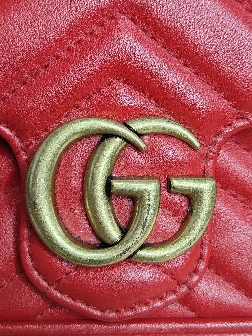 Gucci GG Marmont Super Mini Bag Red (Category: Luxury Bags & Wallets) located in Cebu City. Submitted by cherreymie70208 (Listing ID 1427355465, Image 2). Description: Gucci GG Marmont Super Mini bag in red. Features a chevron quilted design with a heart on the back. Includes a chain strap and a GG logo on the front. The interior has a leather tag with the Gucci logo and serial number. The bag has a snap closure and a gold-tone chain strap..