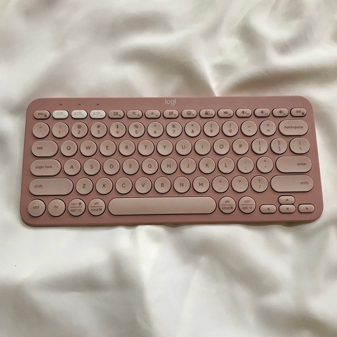 Logitech Pebble Keys 2 K380s Wireless Keyboard (Category: Computer Keyboard) located in Bauang. Submitted by tavias.shop (Listing ID 1427367818, Image 2). Description: Logitech Pebble Keys 2 K380s wireless keyboard in a dusty rose color. It is a multi-device, portable keyboard. The keyboard has round keys and a compact design. The box is included. The back of the keyboard has the model information. It is a Bluetooth keyboard..