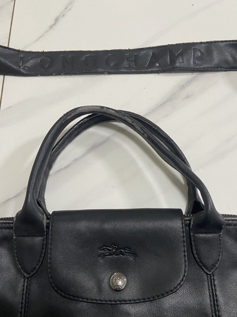 Longchamp Black Leather Handbag with Shoulder Strap (Category: Luxury Bags & Wallets) located in Borongan. Submitted by thrivory.ph (Listing ID 1427374523, Image 2). Description: - Longchamp black leather handbag. - Includes detachable shoulder strap. - Features Longchamp logo details. - Made in France. - Last 2 pics flaws.