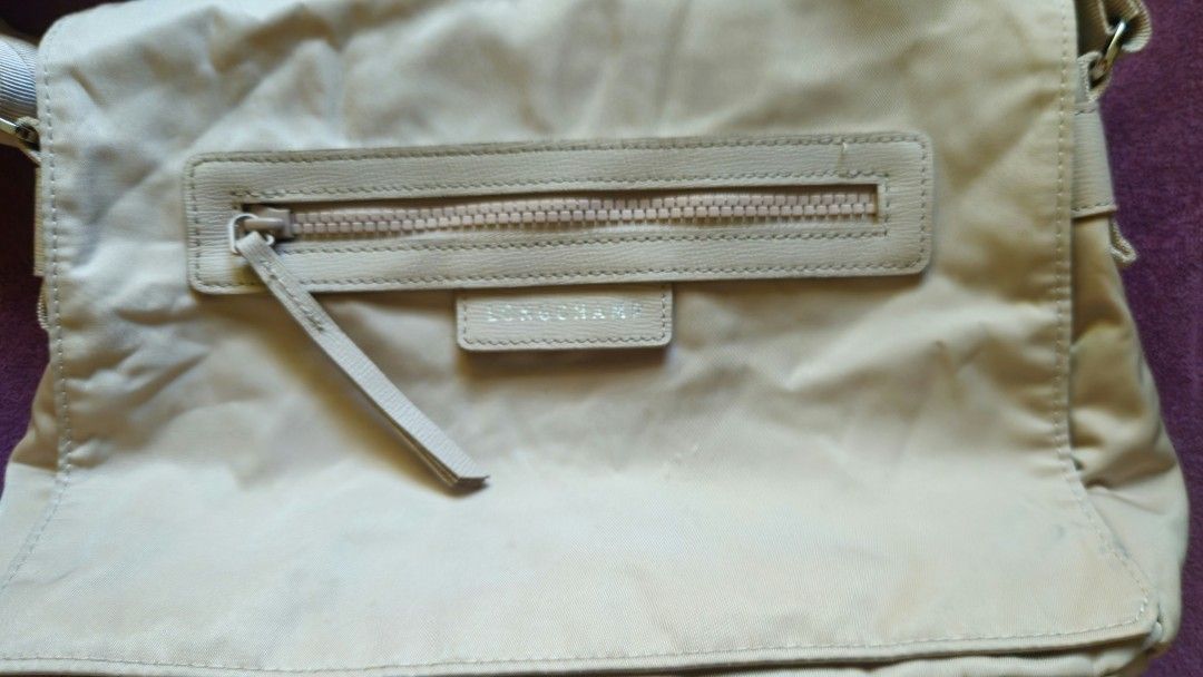 Longchamp Paris Shoulder Bag (Category: Luxury Bags & Wallets) located in Mandaue City. Submitted by ty_trading.ph (Listing ID 1427339217, Image 2). Description: Authentic Longchamp shoulder bag in a neutral beige color. Features a zippered main compartment and an additional zippered pocket on the front. Includes an adjustable shoulder strap. The interior is lined with a matching fabric. Made in France..